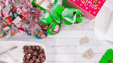 Düz yatıyordu. Adım adım. Ev yapımı macadamia şekerlemesi küçük hediye paketlerine konuyor..