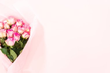 Düz yatıyordu. Pembe arka planda pembe bir kağıda sarılmış taze pembe gül demeti..