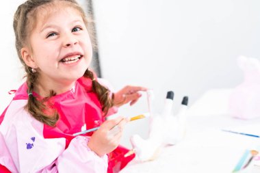 Küçük kız COVID-19 salgınında evde uzaktan öğrenim için sanat projesi üzerinde çalışıyor..