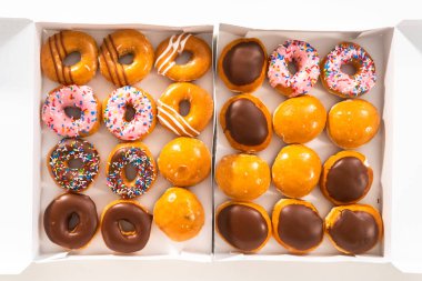 Düz yatıyordu. Beyaz bir karton kutuda mağazadan alınmış donutların çeşitliliği.