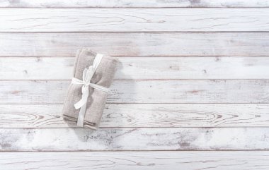 Düz yatıyordu. Beyaz ahşap bir masada yeni bir peçete yığını..