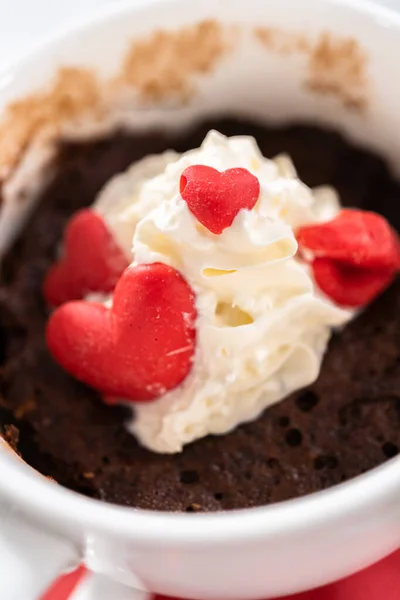ホイップクリームとチョコレートの心と唇で装飾されたチョコレートマグカップケーキ — ストック写真