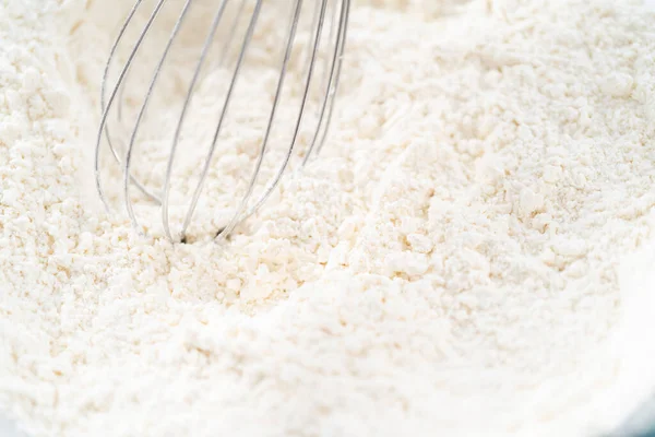 Mixing ingredients in a glass mixing bowl to bake July 4th bundt cake with chocolate stars.