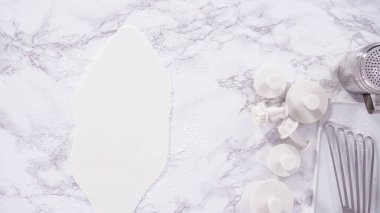 Düz yatıyordu. Adım adım. Beyaz fondantımızı mermer tezgahta yuvarlıyoruz..