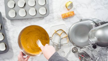 Düz yatıyordu. Balkabağı aromalı kek hamuru. Hamur hamuru kepçesiyle kapkek tepsisine dolgu malzemesi..