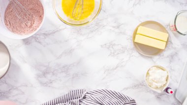 Düz yatıyordu. Adım adım. Kırmızı kadife kek pişirmek için bardakta ıslak malzemeler karıştırıyorum..