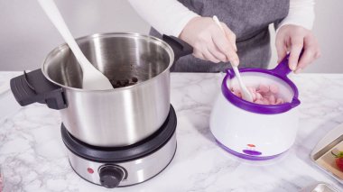 Adım adım. Çikolata parçacıkları eriyen kaplarda eriyor..