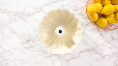 Düz yatıyordu. Adım adım. Bitkisel kısaltmalı ve beyaz un serpiştirilmiş yağlı kek tavası..