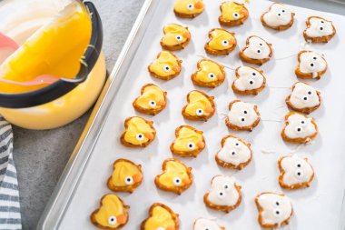 Çikolata kaplı kraker tavşanları ve beyaz ve sarı çikolatalı ördek yavruları hazırlanıyor..