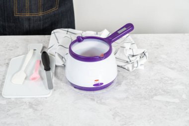 Çikolata parçacıkları eriyor elektrikli şeker tenceresinde.