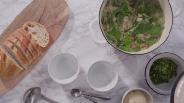 Beyaz kaselerde vejetaryen beyaz fasulye çorbası servis ediyorlar..