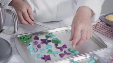 Vanilyalı kekleri süslemek için silikon kalıplı çikolata denizkızı kuyruğu yapıyorum..