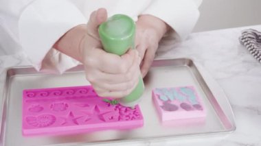 Vanilyalı kekleri süslemek için silikon kalıplı çikolata denizkızı kuyruğu yapıyorum..