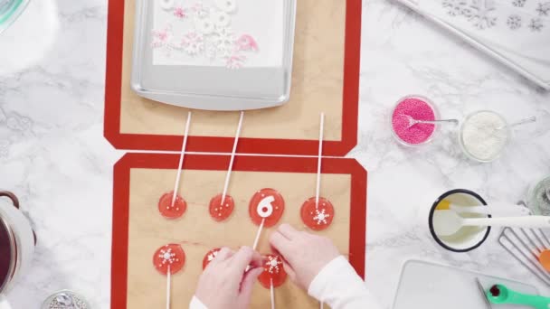 눈송이와 스프링클러를 사용하여 분홍색 롤리팝을 만드는 — 비디오