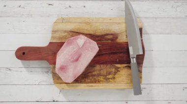 Ağaç kesme tahtasıyla organik ballı jambon kesmek.