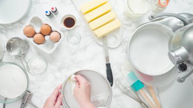 Adım adım. Düz yatıyordu. Üç katlı vanilyalı kek pişirmek için tereyağlı kek tavaları yağlamak..