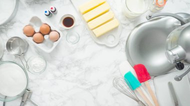 Adım adım. Düz yatıyordu. Üç katlı vanilyalı kek pişirmek için mutfak mikserinin malzemelerini karıştırıyorum..