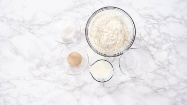 Düz yatıyordu. Adım adım. Mutfak masasında çörek pişirmek için gerekli malzemeler..