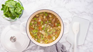 Dökme demir Hollanda fırınında vejetaryen beyaz fasulye çorbası pişirmek.