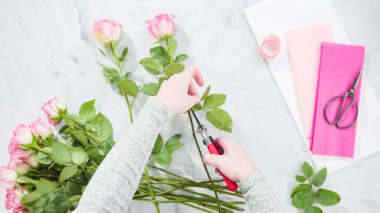 Düz yatıyordu. Adım adım. Çiçekçi pembe güllerden buket hazırlıyor..