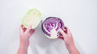 Düz yatıyordu. Adım adım. Beyaz arka planda organik yeşil ve mor lahana..