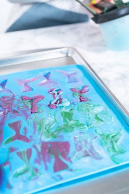 Çikolata kalıplarını erimiş çikolatayla doldurup çikolata denizkızı kuyruğu yapıyorlar..