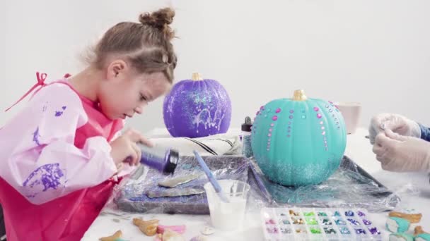 Kleines Mädchen Dekoriert Ihren Halloween Kürbis Mit Glitzer — Stockvideo