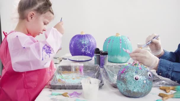 Klein Meisje Versieren Haar Halloween Pompoen Met Glitter — Stockvideo