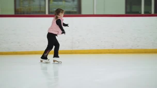 Kleines Mädchen Übt Eiskunstlauf Auf Einer Überdachten Eisbahn — Stockvideo