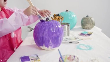 Süslü deniz kızı Cadılar Bayramı balkabağı yaratmak için akrilik boyalı balkabağı boyamak.