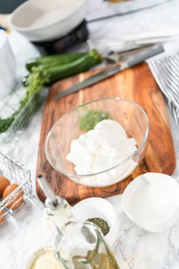 Ekşi krema ve otları karıştırarak kabak kekleri için ekşi krema yapıyorum..