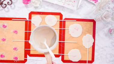 Düz yatıyordu. Ev yapımı lolipoplar yapmak için silikon paspaslara karamelize şeker dökmek..