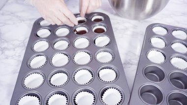 Adım adım. Mini çikolatalı kekler pişirmek için kek hamurunu mini kek kuyruklarına karıştırmak..