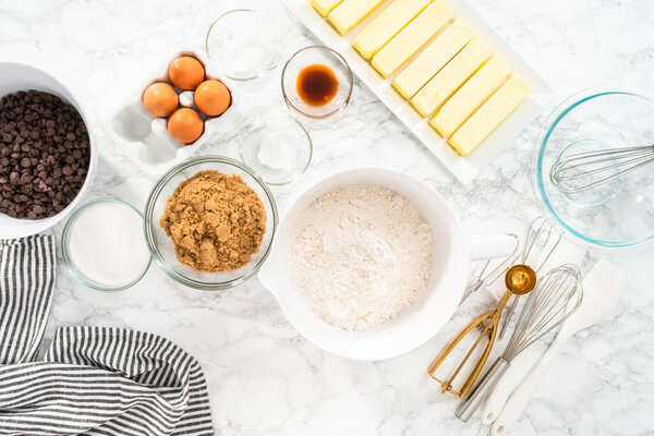 Mixing ingredients in a glass mixing bowl to bake chocolate chip cookies.