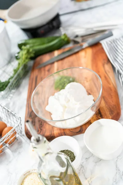 Ekşi krema ve otları karıştırarak kabak kekleri için ekşi krema yapıyorum..