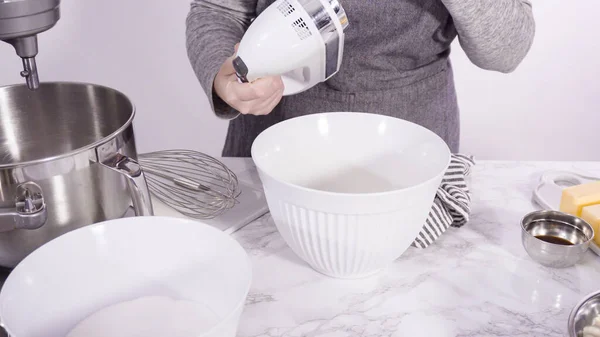 Step by step. Mixing ingredients in standing kitchen mixer to bake funfetti cake.