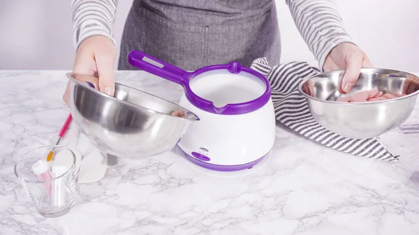 Adım adım. Çikolatalı şekerleri eritmek elektrikli bir şeker tenceresinde erir..