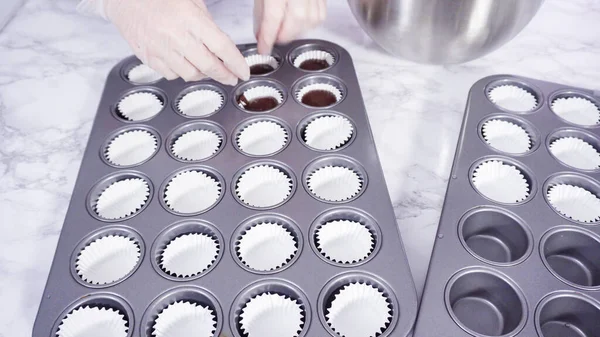 Adım adım. Mini çikolatalı kekler pişirmek için kek hamurunu mini kek kuyruklarına karıştırmak..