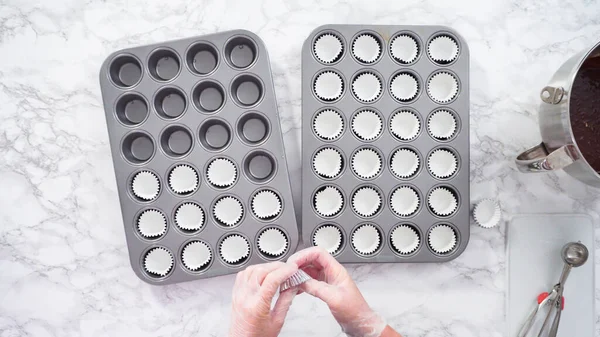 Düz yatıyordu. Adım adım. Mini çikolatalı kek pişirmek için kek kalıplarıyla kek tepsisi hazırlıyorum..