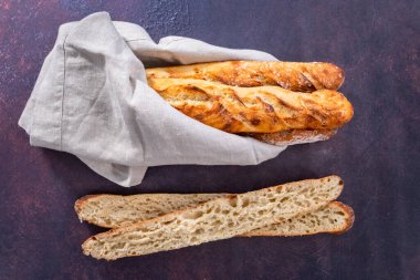 Düz yatıyordu. Taze pişmiş küçük Fransız ekmeği..