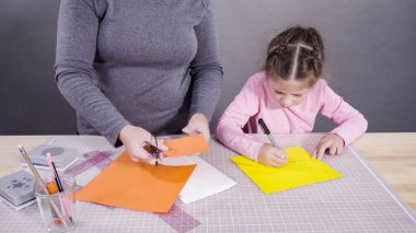 İnşaat kağıdından el yapımı Babalar Günü kartı yapan küçük bir kız..