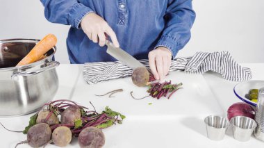 Adım adım. Sirkeli salata için beyaz bir kesme tahtasındaki sebzeleri dilimliyorum..