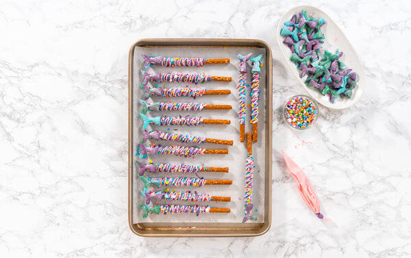 Mermaid chocolate pretzel rods drizzled with pink and purple chocolate and covered with sprinkles.