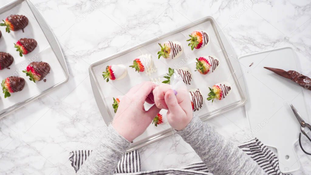 Flat lay. Step by step. Drizzling melted chocolate from pastry piping bag to chocolate covered strawberries.