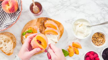 Düz yatıyordu. Adım adım. Ciabatta ekmeğinde ricotta ve şeftalili tost yapmak için organik şeftali dilimliyorum..