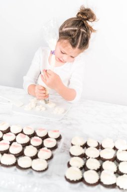 Küçük kız İtalyan tereyağı kreması tatlandırması yapıyor..