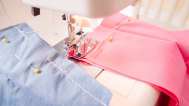 Koronavirüs salgını için dikiş makinesiyle pamuk yüz maskesi dikiyorum..