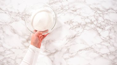 Düz yatıyordu. Adım adım. Limonlu kek hazırlamak için cam karıştırma kaselerinde bulunan malzemeler..