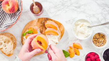 Düz yatıyordu. Adım adım. Ciabatta ekmeğinde ricotta ve şeftalili tost yapmak için organik şeftali dilimliyorum..