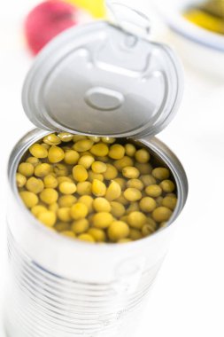 Vinaigrette salatası hazırlamak için açılmış bezelye konservesi..